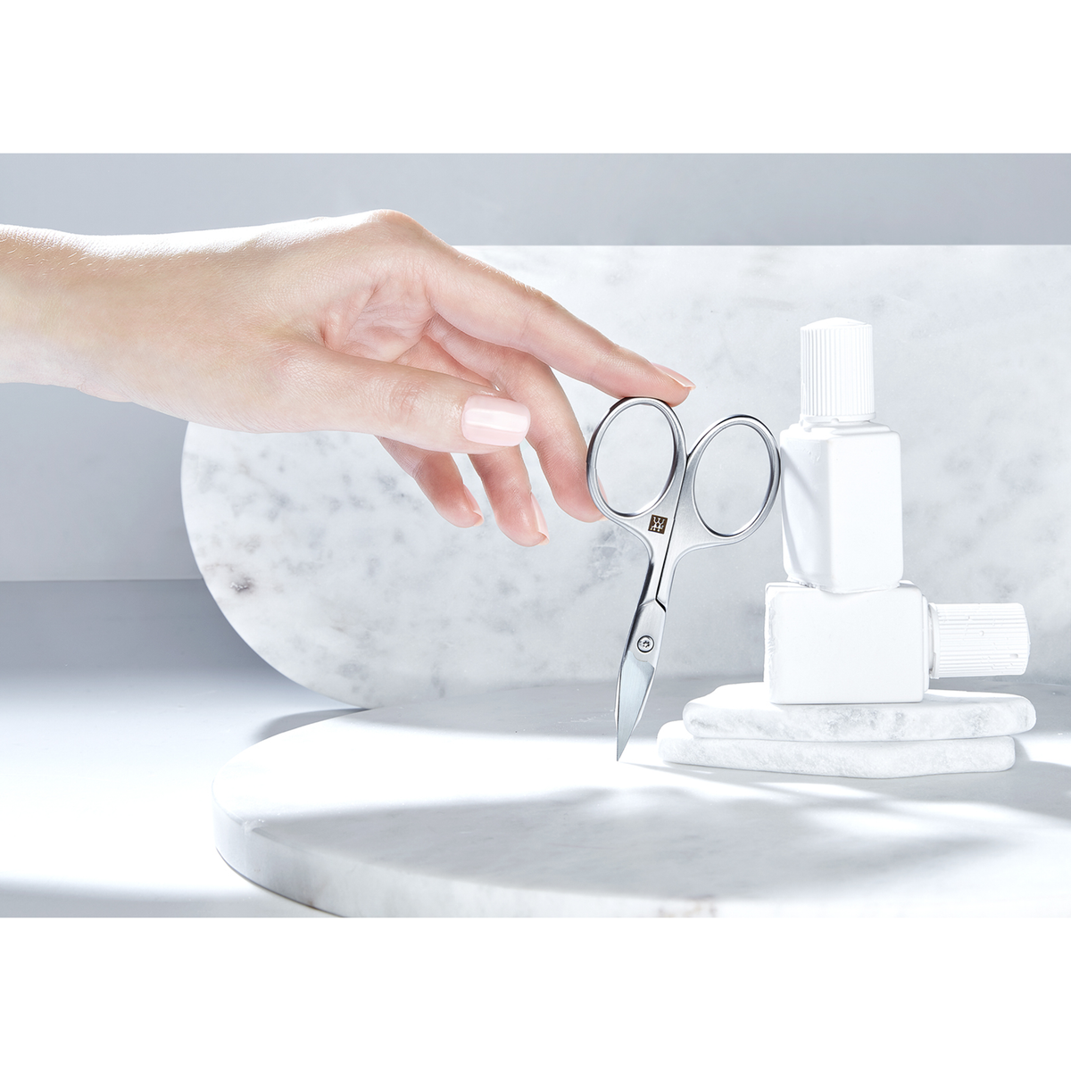 Sehr hochwertige Darstellung der ZWILLING Premium Nagel- und Nagelhautschere inmitten von artifiziellen Marmor- und Steinobjekten.