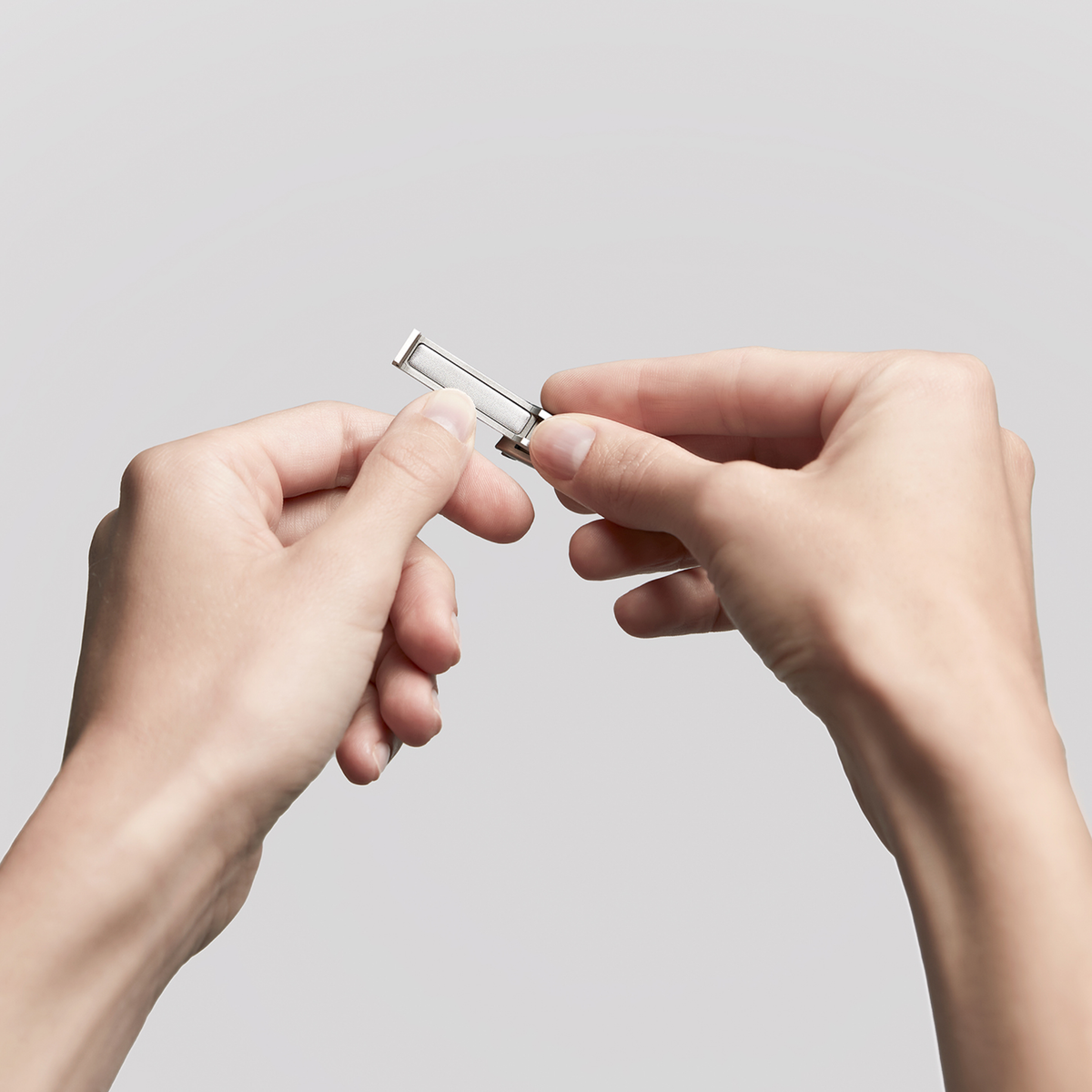 Anwendung der integrierten Nagelfeile eines ZWILLING Premium Nagelknipsers aus rostfreiem Edelstahl am linken Daumennagel.